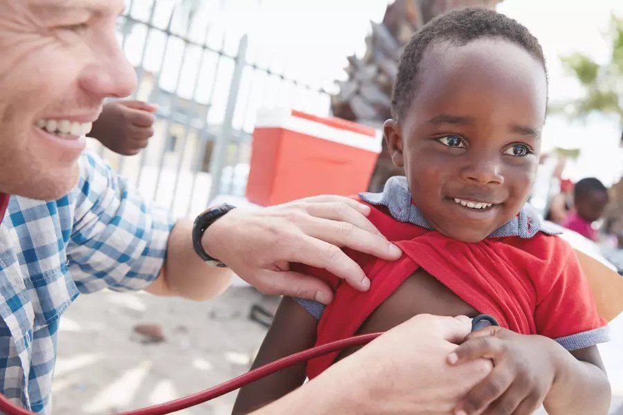 A health worker examining a smiling child during an IRFS Global medical outreach